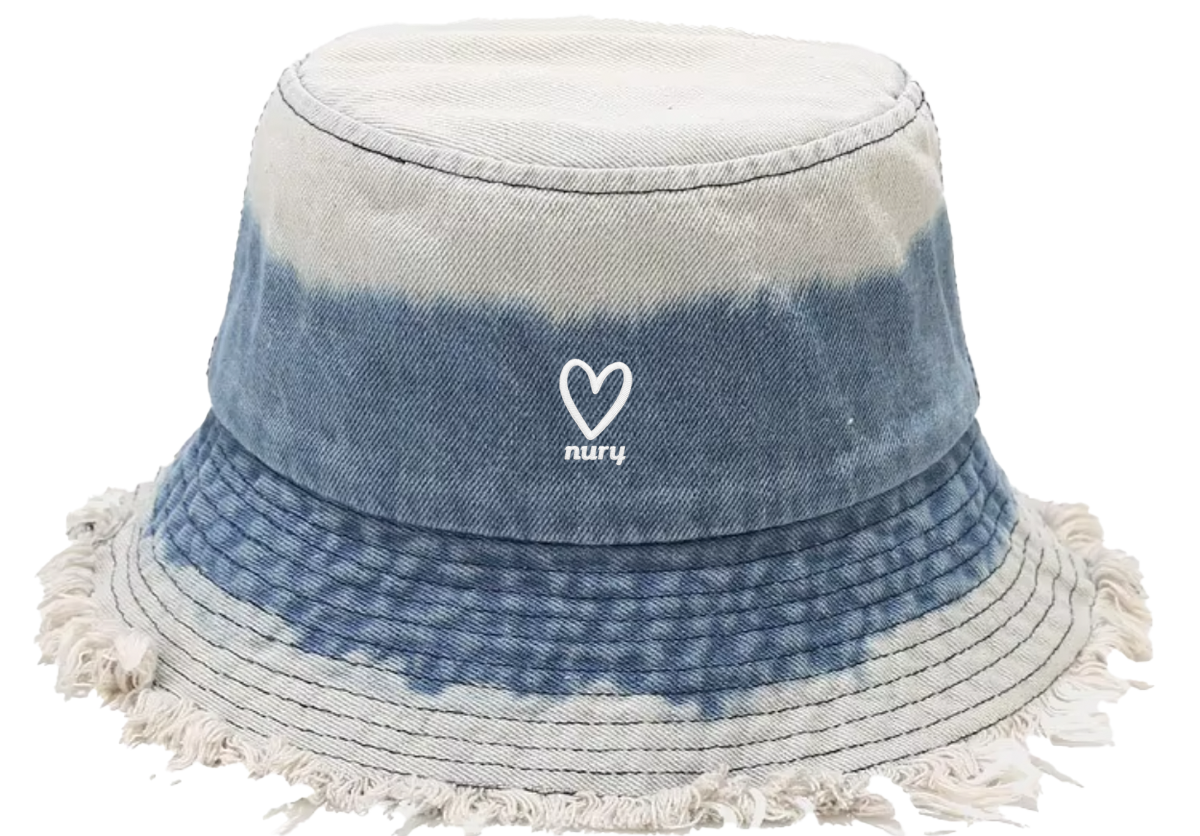 Close-up of Nury tie dye light blue denim frayed bucket hat brim and heart embroidery
